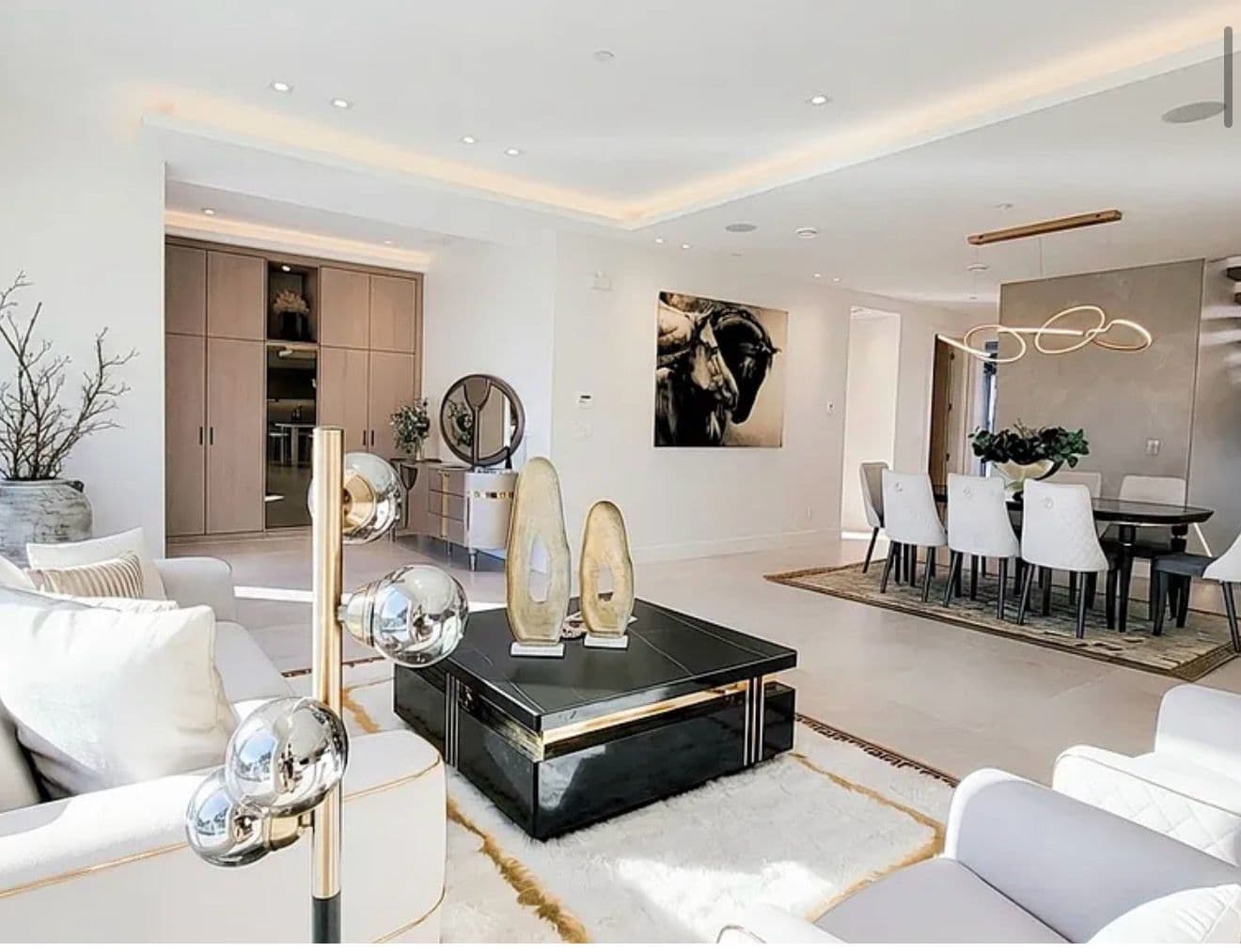 Grand staged living room with a black-and-gold cocktail table and statement artwork