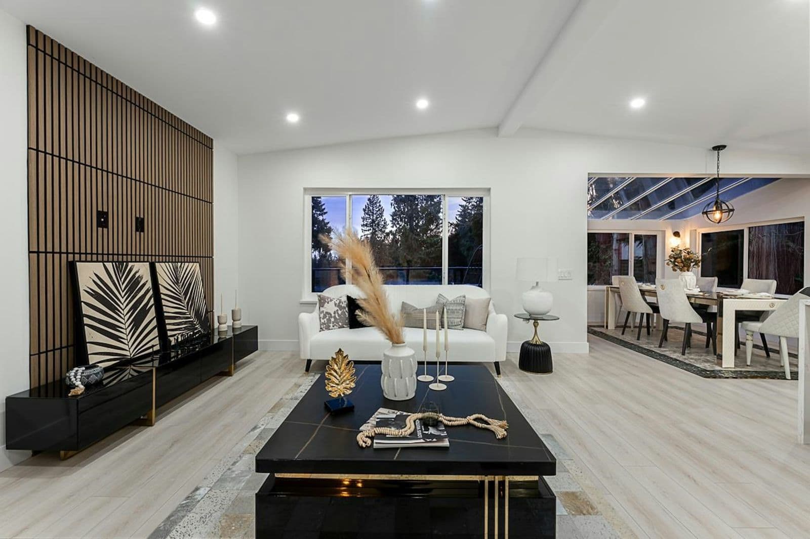 Staged living and dining room with a walnut slat wall and a marble cocktail table